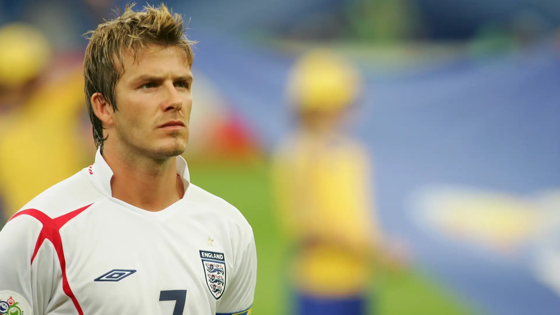 David Beckham wearing England's white football shirt on the pitch.