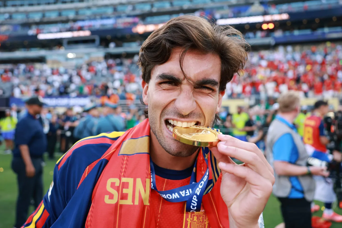 Ferran Torres smiling and biting his gold medal on the field after Spain won the 2026 FIFA World Cup.