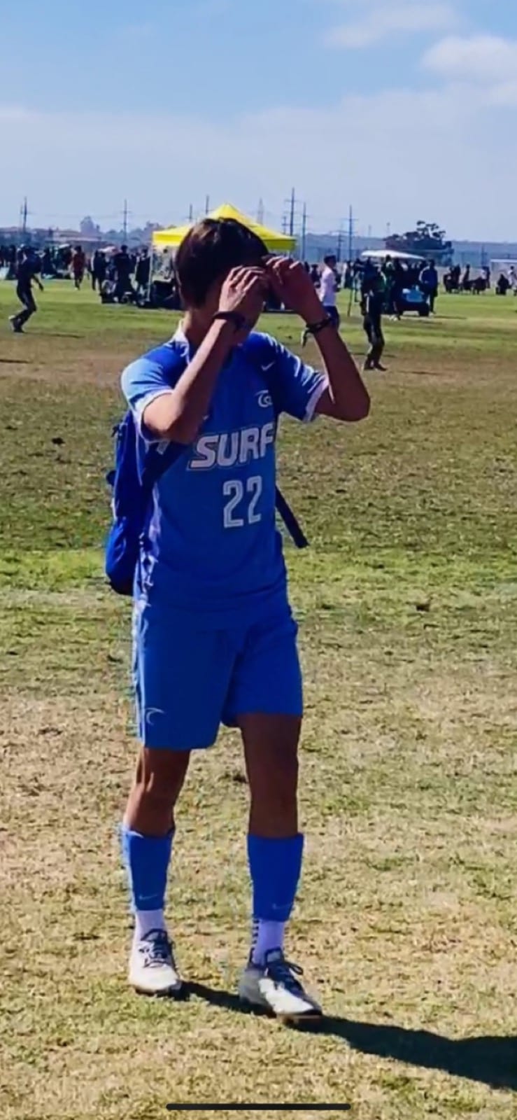Jonathan standing on a soccer field in a blue jersey