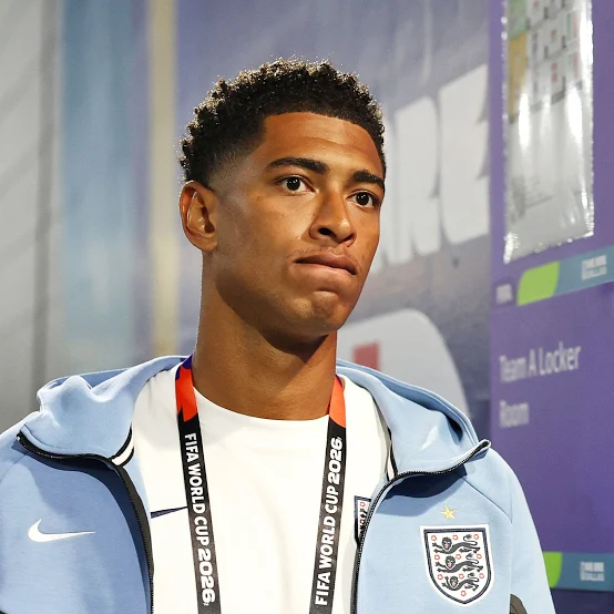 Jude Bellingham wearing a pale blue England jacket and a FIFA World Cup 2026 medal after representing his country.