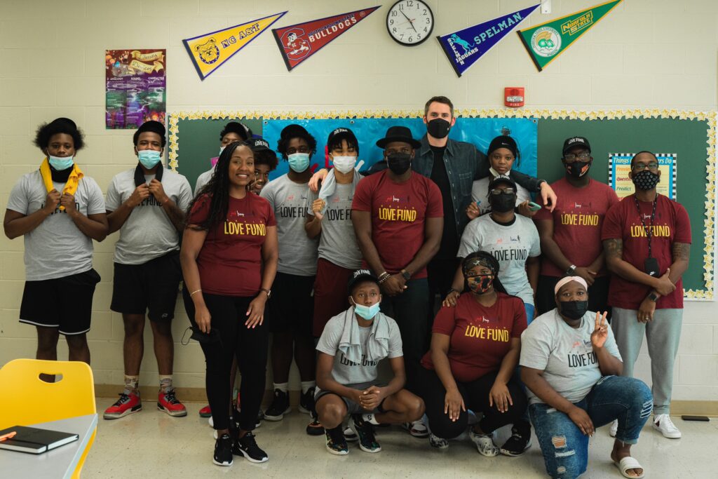 Kevin Love with students and educators wearing Kevin Love Fund shirts in a classroom