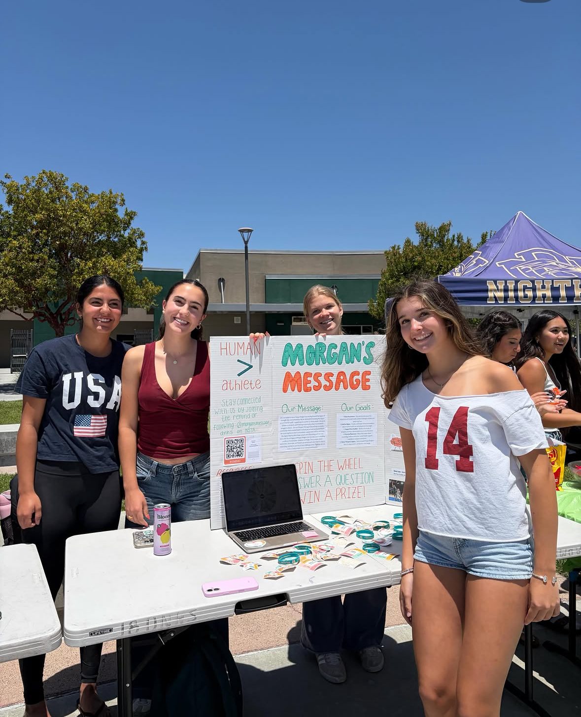 Morgan's Message DNHS student ambassadors standing beside a student-athlete mental health display table